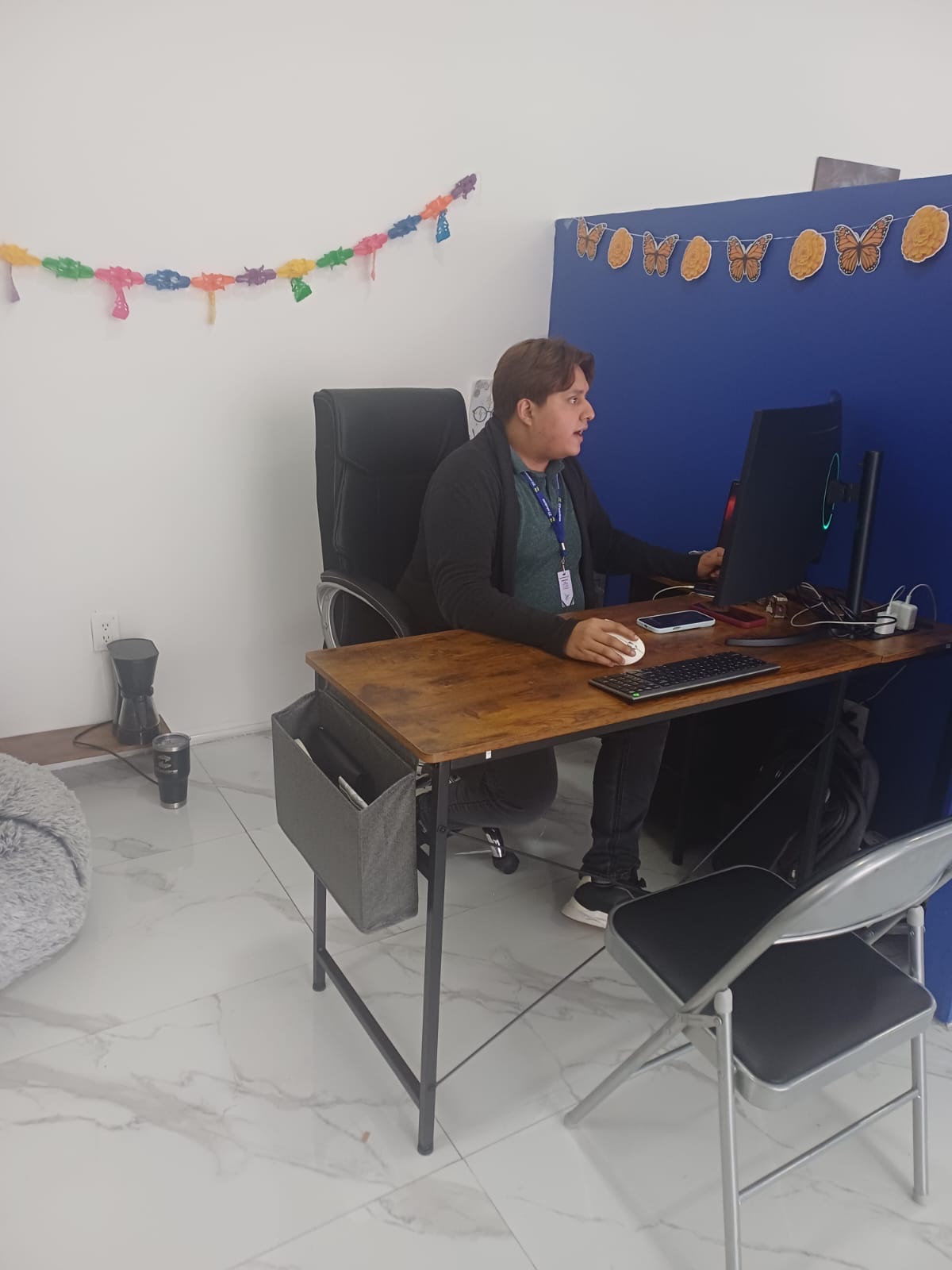 Colaborador de ZR Soluciones trabajando en su escritorio, decorado para Día de Muertos