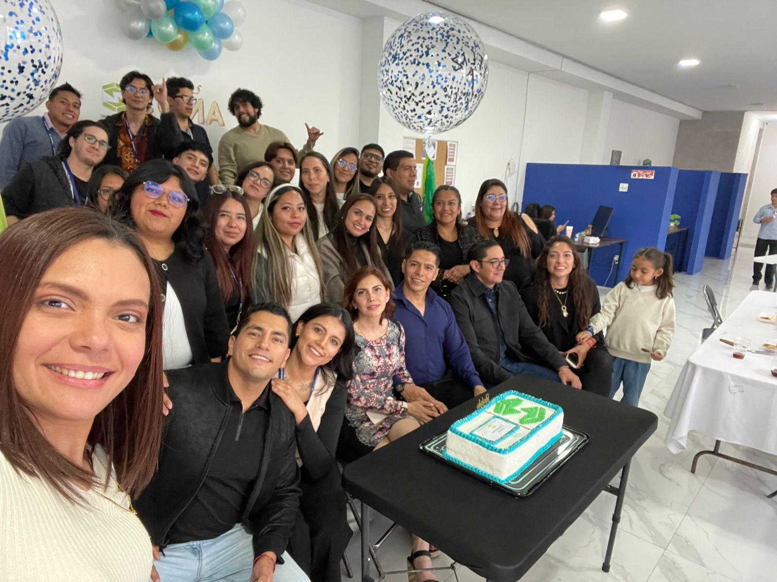 Equipo de ZR Soluciones celebrando juntos con un pastel de la marca en la oficina